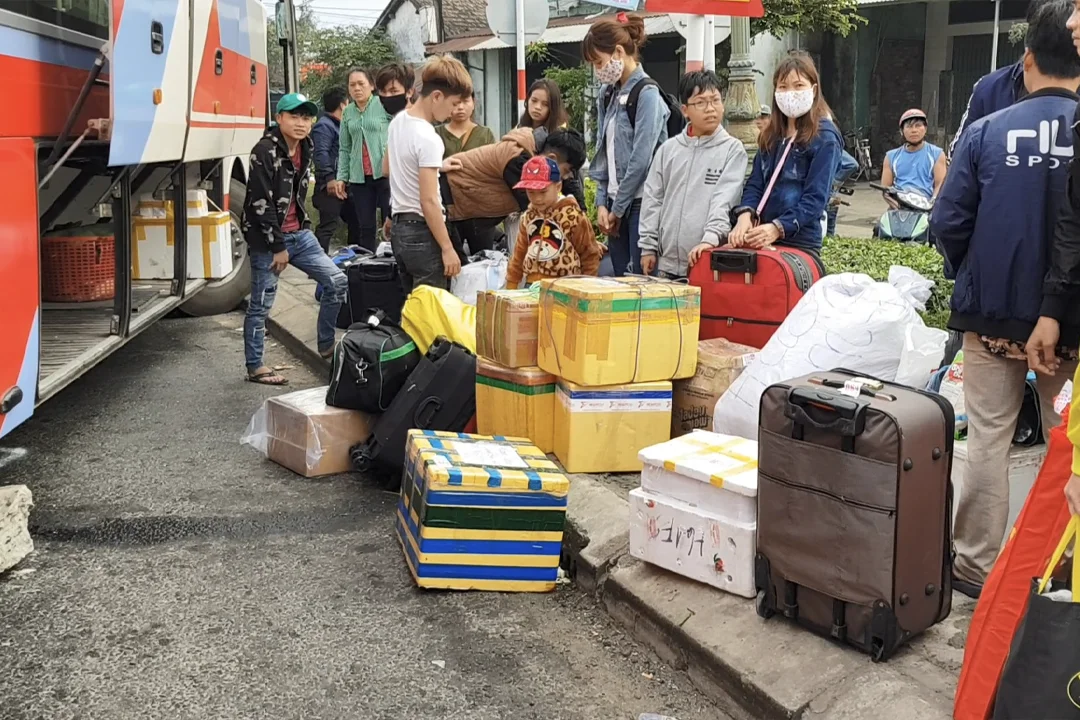 Customers line up to store their luggage before boarding the bus.