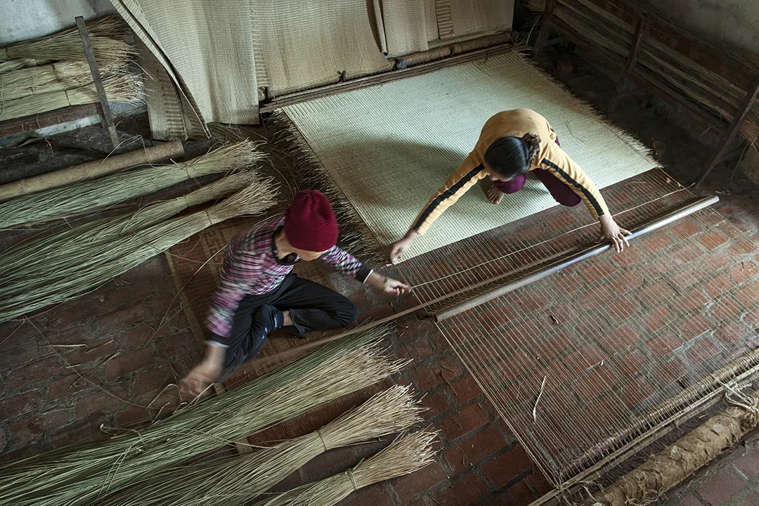 Weaving mats using traditional methods.